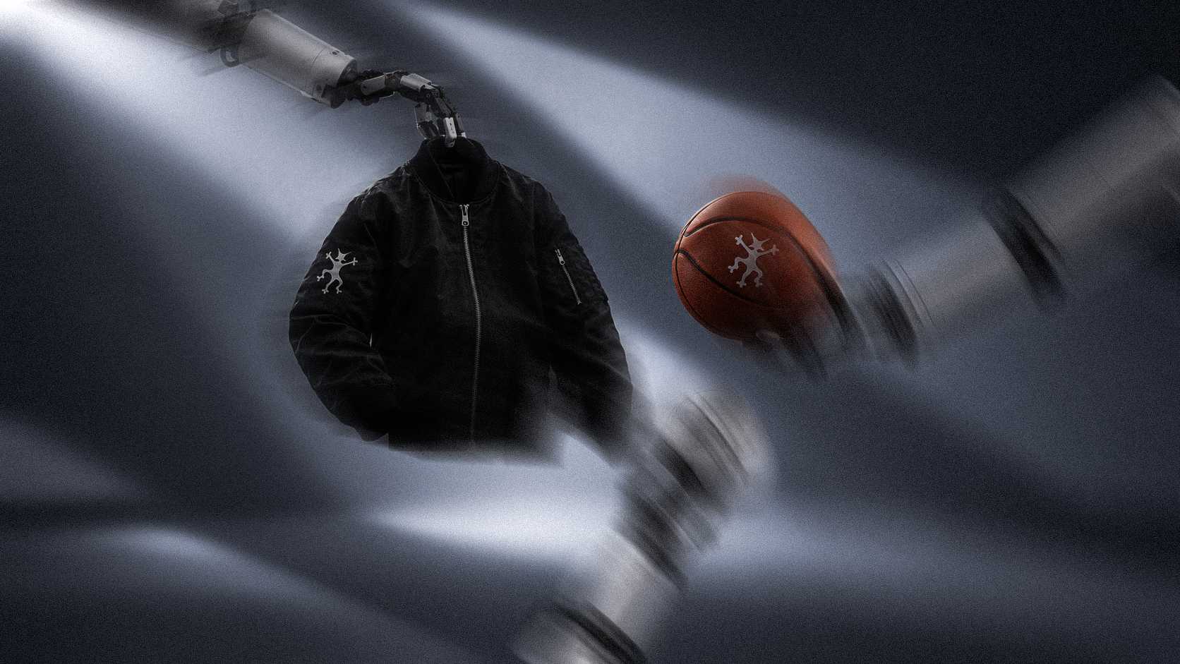 A black bomber jacket and a branded basketball suspended by robotic arms in motion-blurred light.